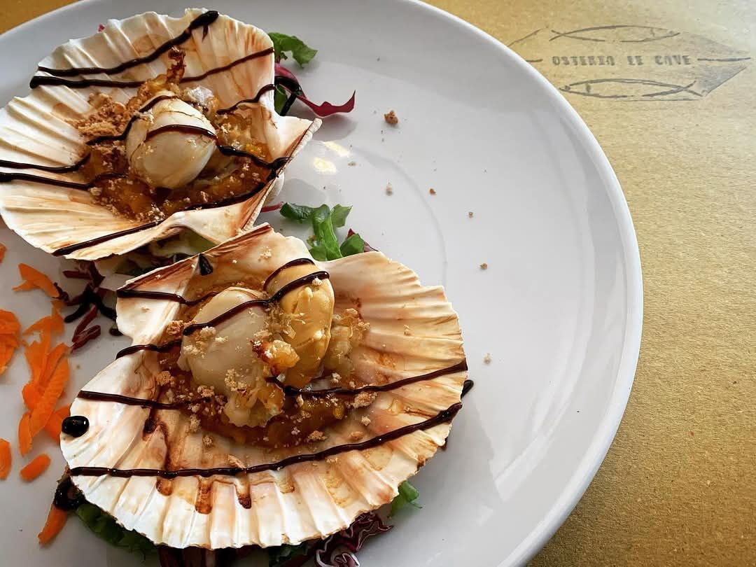 Capesante gratinate servite nella loro conchiglia con riduzione di aceto balsamico