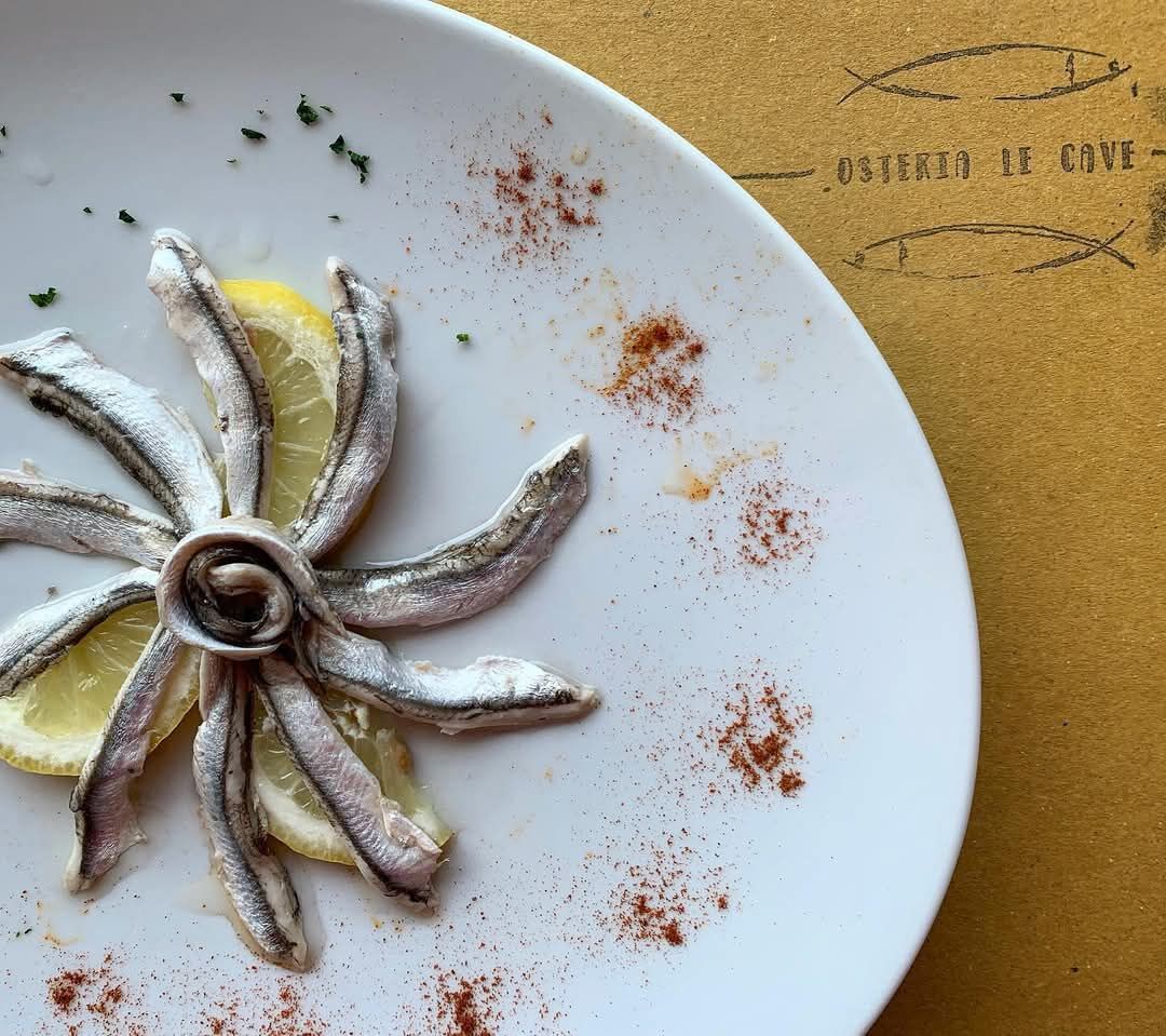 Alici marinate disposte a rosa con fette di limone