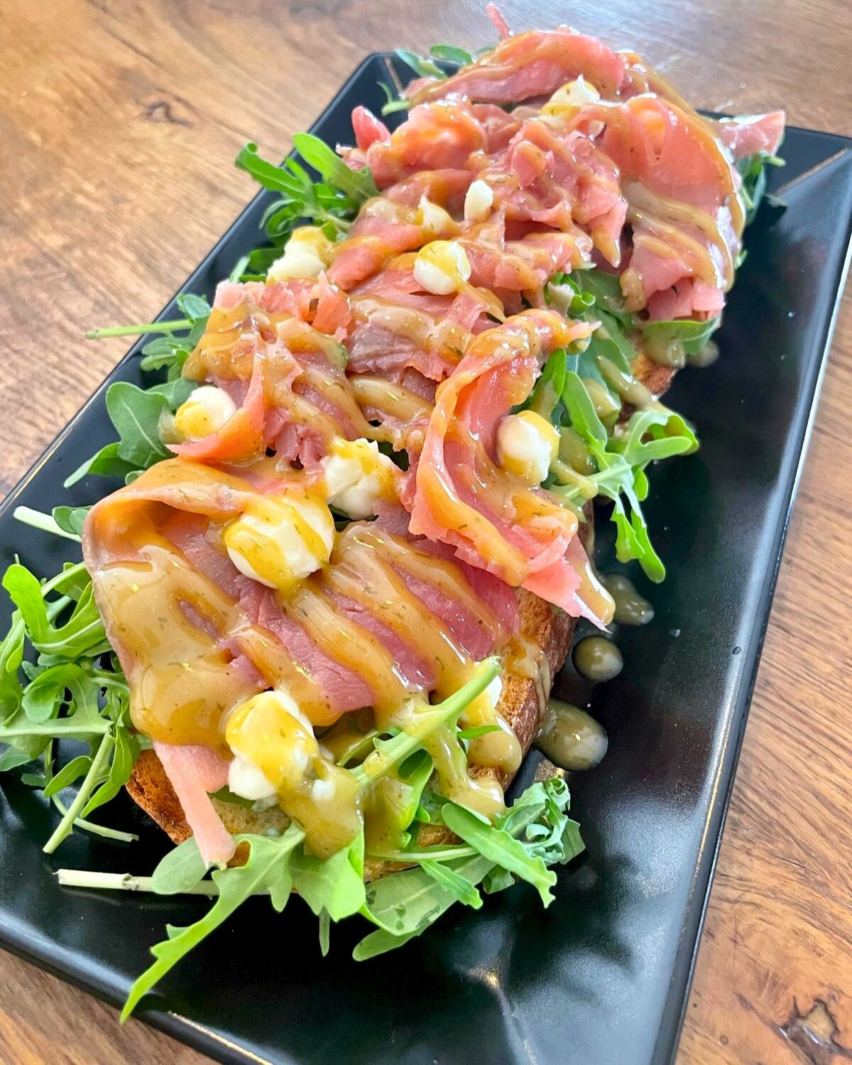 Bruschette con tartare di pesce, rucola e perle di burrata