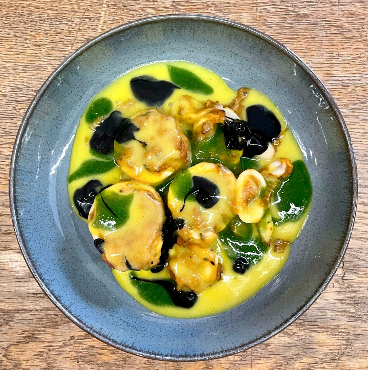 Capesante scottate con crema di zafferano, salsa al basilico e riduzione di aceto balsamico